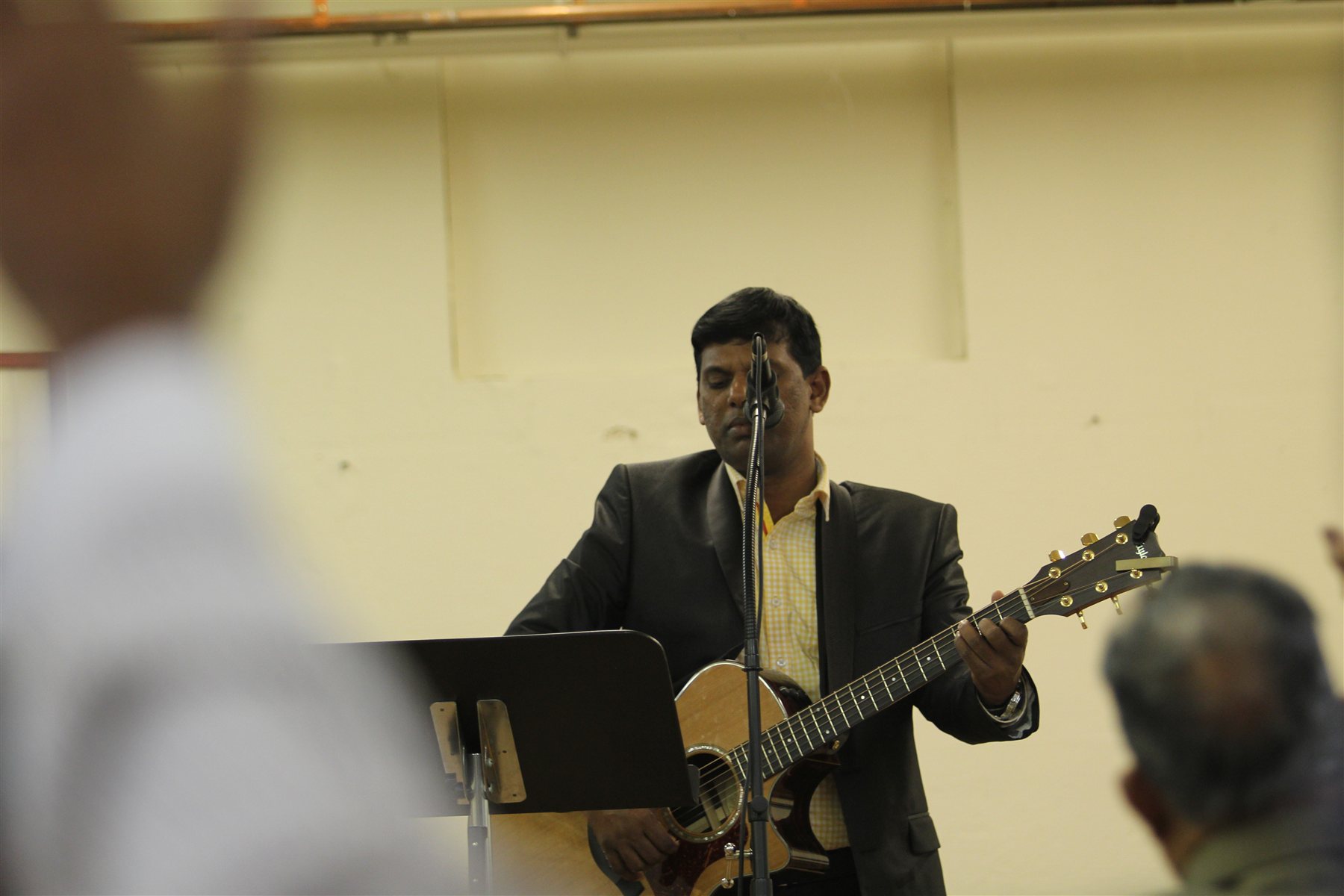 Pastor Samuel Wilson leading worship with an acoustic guitar